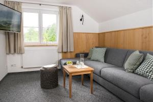 ein Wohnzimmer mit einer Couch und einem Tisch in der Unterkunft Chalet Hageberg ab Mai freie Fahrt mit Bergbahnen in Bolsterlang