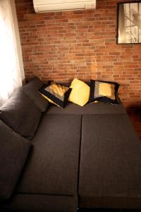 a couch against a brick wall with pillows on it at El Palomar in Valladolid