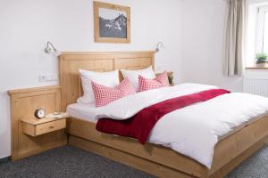 a bedroom with a large bed with red and white pillows at Alpenchalet Hageberg in Bolsterlang