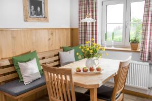 ein Esszimmer mit einem Tisch und einer Vase aus Blumen in der Unterkunft Chalet Hageberg ab Mai freie Fahrt mit Bergbahnen in Bolsterlang