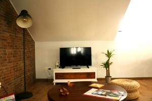 a living room with a flat screen tv and a table at Precioso Ático céntrico - El Palomar in Valladolid +16 photos