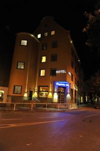 Hotel Bergischer Hof في راتينغن: مبنى الفندق في الليل مع ضوء أزرق