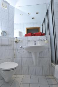 Hotel Bergischer Hof في راتينغن: حمام أبيض مع حوض ومرحاض