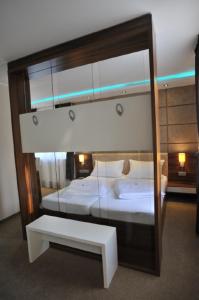 a bedroom with two beds and a mirror and a bench at Hotel Bergischer Hof in Ratingen