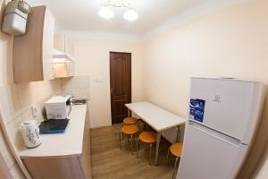 リヴィウにあるКвартира в центрі на вулиці Вірменській 12 є дві спальні двуспальні ліжкаのキッチン(冷蔵庫、テーブル、椅子付)