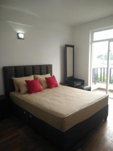 un letto con due cuscini rossi in una camera da letto di Bella Vista Luxury Apartments Nuwara Eliya Sri Lanka a Nuwara Eliya