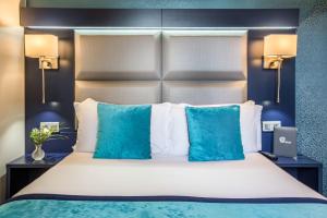 um quarto com uma cama grande e almofadas azuis em Prince Albert Montmartre em Paris