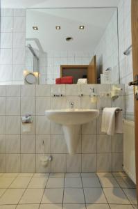 La salle de bains est pourvue d'un lavabo et d'un miroir. dans l'établissement Hotel Bergischer Hof, à Ratingen
