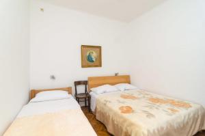 ドゥブロヴニクにあるRooms Ivo 1のベッドが2つあり、壁に絵が飾られている寝室