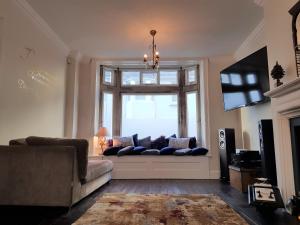 a living room with a couch in front of a window at Camelford House in Brighton & Hove