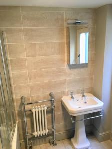 baño con lavabo, espejo y radiador en Camelford House, en Brighton & Hove