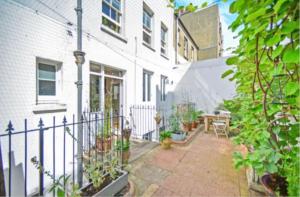 a courtyard of a white house with a fence at Camelford House in Brighton & Hove