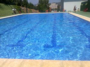 une grande piscine d'eau bleue dans l'établissement Casa Serra de Irta, à Santa Magdalena de Pulpis