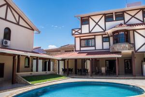 a house with a swimming pool in front of it at Hotel By Armonía Santa Cruz in Santa Cruz de la Sierra