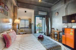 a bedroom with a large bed and a television at Lovely Guesthouse 94 in Hua Hin
