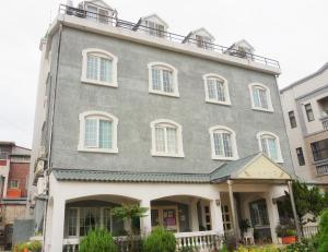een oud gebouw met een balkon erboven bij Red Roof B&B in Jinhu