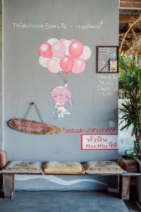 a wall with a picture of a girl with balloons at Lovely Guesthouse 94 in Hua Hin
