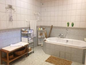 y baño con bañera y lavamanos. en Nora Porta, en Palkonya