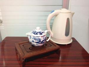 a blue and white pitcher and a tea pot on a table at Asia Travel House in Hong Kong