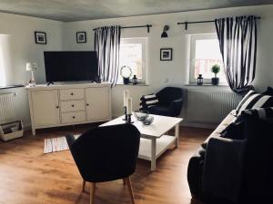 ein Wohnzimmer mit einer Couch, einem Tisch und einem Fernseher in der Unterkunft Ilmhaus 2 in Gaden bei Pförring