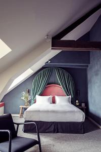 a bedroom with a large bed and a chair at Hotel des Grands Boulevards Experimental in Paris