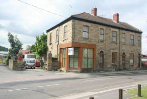 an old brick building on the side of a street at Stonehouse Apartment in Mexborough