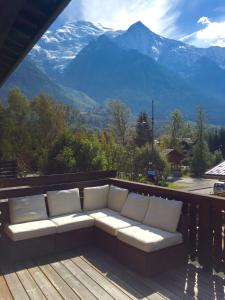 a couch on a deck with a view of mountains at Chamonix Apartment in Chamonix