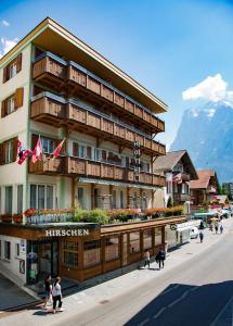a hotel with people walking in front of it at Ferienwohnung Hirschen in Grindelwald