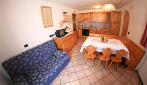 a kitchen with a table and a blue couch at Appartamenti Majon Ladina in Vigo di Fassa