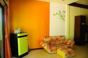 a living room with a chair and an orange wall at Phumimalee Nature View Resort in Nakhon Ratchasima