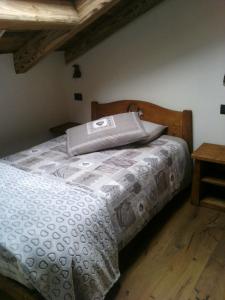 プレ・サン・ディディエにあるLa mansarda delle marmotteのベッドルーム1室(白い掛け布団付きのベッド1台付)