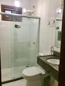 a bathroom with a shower and a toilet and a sink at Casa Barra Grande in Barra Grande
