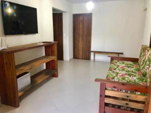 a living room with a couch and a flat screen tv at Casa Barra Grande in Barra Grande