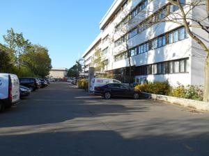 a street with cars parked in front of a building at Mercure Versailles Paris Ouest in Versailles