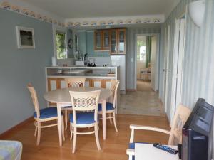 een keuken en eetkamer met een tafel en stoelen bij Résidence De La Corniche - vue sur mer in Plestin-les-Grèves