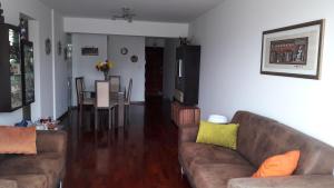 sala de estar con 2 sofás y comedor en Residencial Pershing en Lima