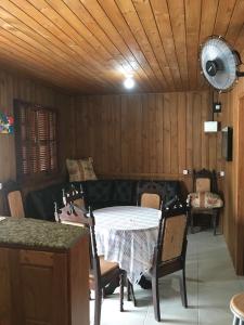 a dining room with a table and chairs and a fan at Casa Pinheira in Palhoça