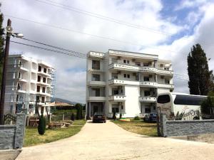 a bus parked in front of a white building at Apartments Perezaj II in Ulcinj