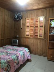 sypialnia z łóżkiem i telewizorem w obiekcie Casa Pinheira w mieście Palhoça