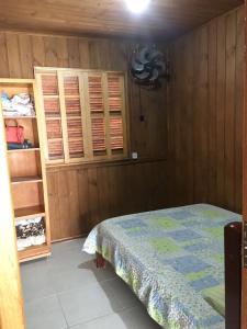 sypialnia z łóżkiem i drewnianymi ścianami w obiekcie Casa Pinheira w mieście Palhoça