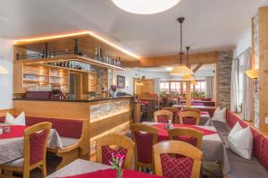 un restaurante con mesas y sillas y un bar en Gasthof Edelbrunn en Ramsau am Dachstein