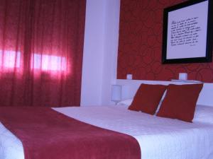 a bedroom with a large bed with red curtains at Hostal Don Pepe in Figueres