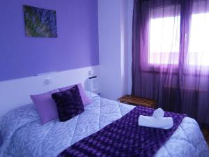 a bedroom with a large bed with purple pillows at Hostal Don Pepe in Figueres