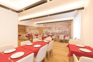 a dining room with red tables and white chairs at Belvenu Boutique Hotel in Glorenza