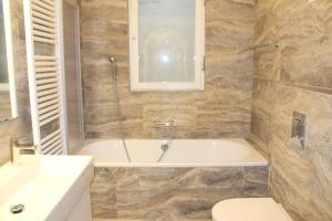 a bathroom with a tub and a toilet and a sink at Barony Le Pergole Lugano - 2 persons in Lugano