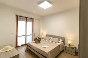 シルヴィ・マリーナにあるZaffiro Luxury Silvi Vacanzaの白いベッドルーム(ベッド1台、窓付)
