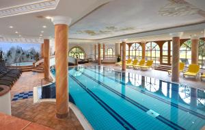 a swimming pool in a hotel with a large building at Hotel Residenz Hochland in Seefeld in Tirol