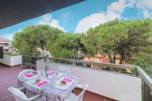 un tavolo e sedie su un balcone alberato di Zaffiro Luxury Silvi Vacanza a Silvi Marina