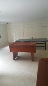 a pool table in a room with a ping pong table at Apartamento Riviera in Bertioga