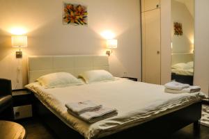 - une chambre avec un grand lit et des serviettes dans l'établissement Guest house Altay, à Karakol